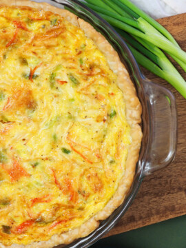 A pie plate full of baked crab quiche.