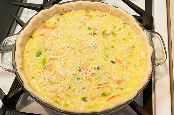 Unbaked crab quiche in an unbaked pie shell ready to go into the oven.