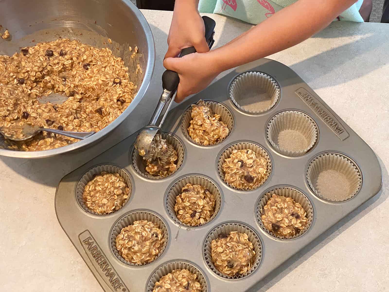 Filling a muffin tin with oatmeal batter