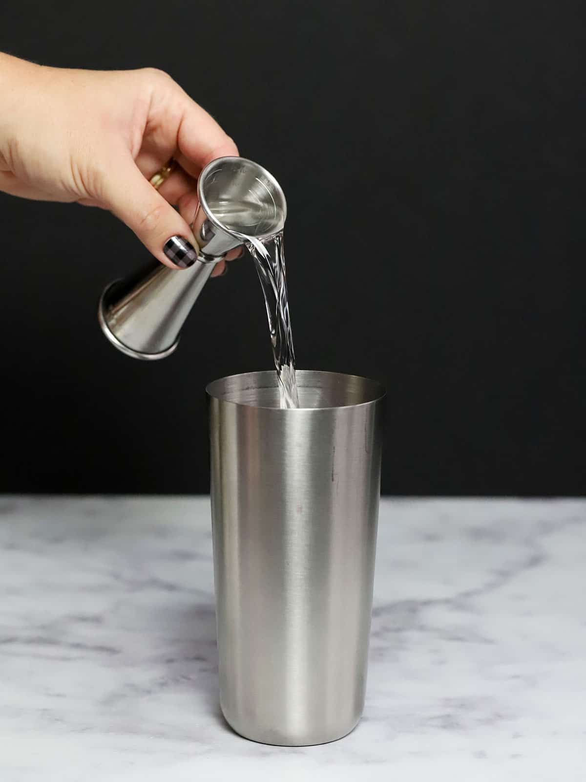 Vodka being poured into a cocktail shaker