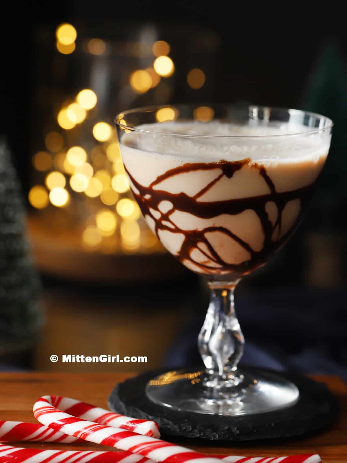 A glass drizzled with chocolate syrup and filled with peppermint mocha martini.