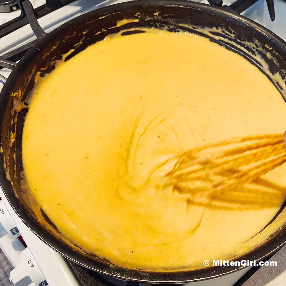 Whisking the finished cheese sauce.