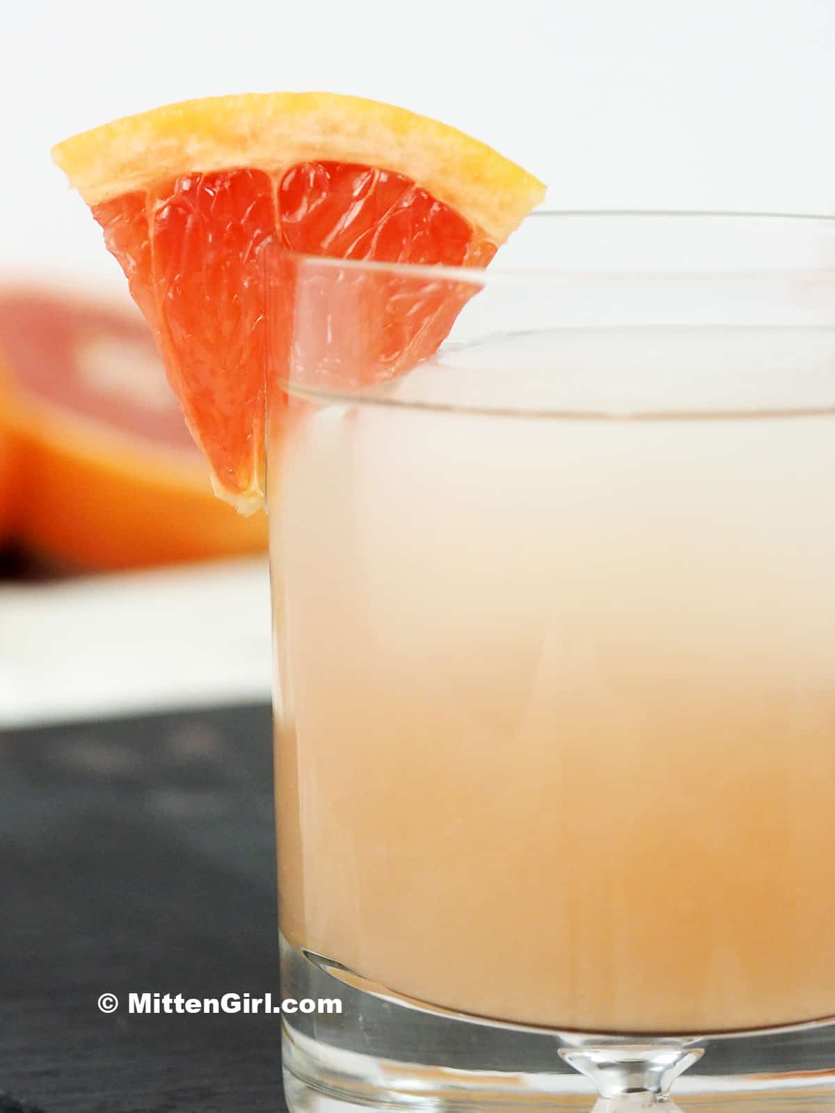 A paloma cocktail garnished with a slice of grapefruit. 