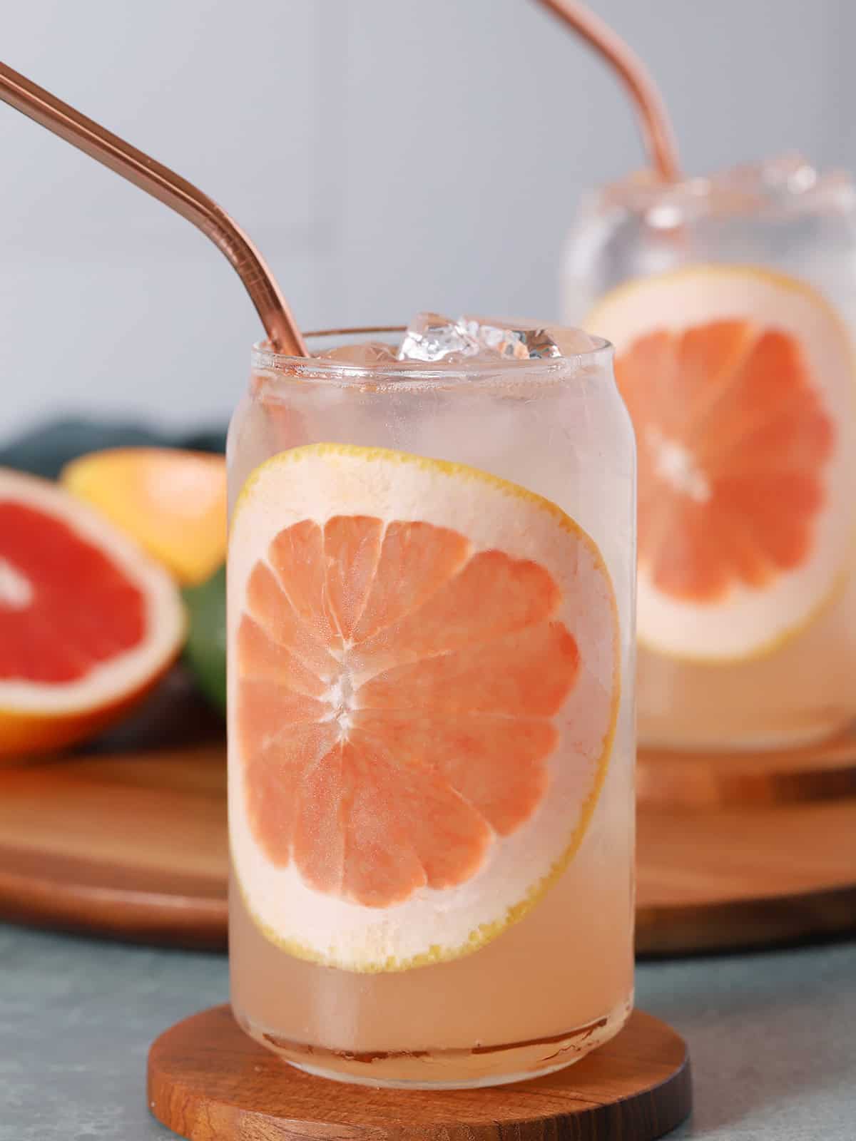 Glasses of Paloma cocktails garnished with large slices of grapefruit.