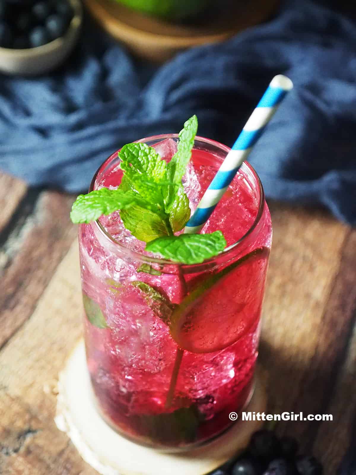 A glass of blueberry mojito mocktail.