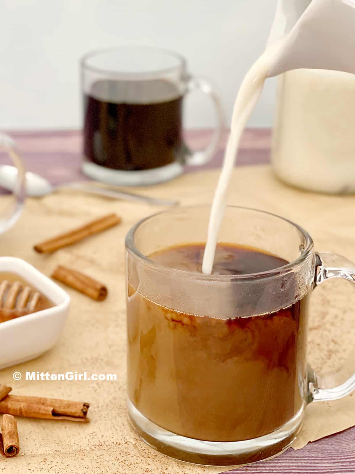 Miel milk being poured into a cup of coffee.