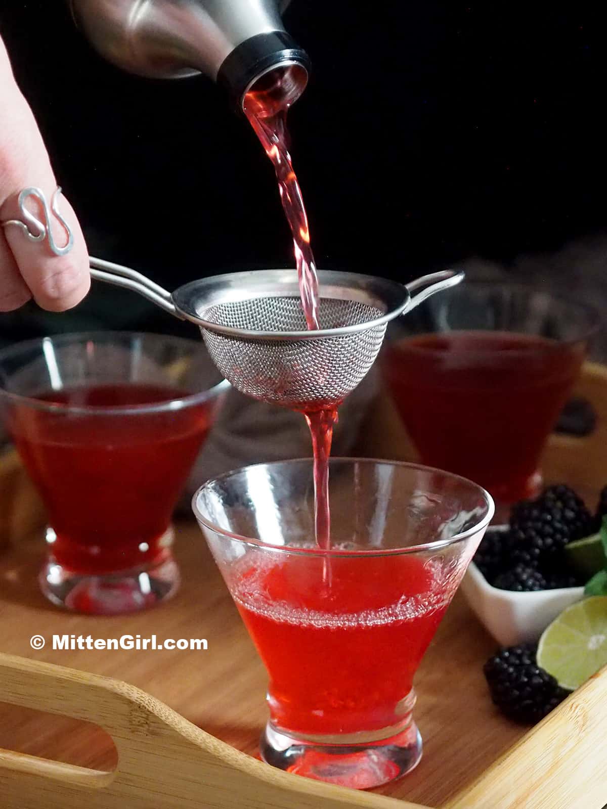 Double straining a blackberry martini.