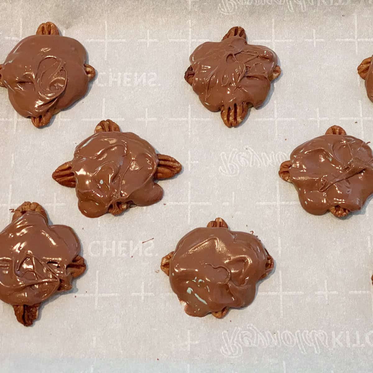 Pecan turtles with a fresh topping of chocolate.