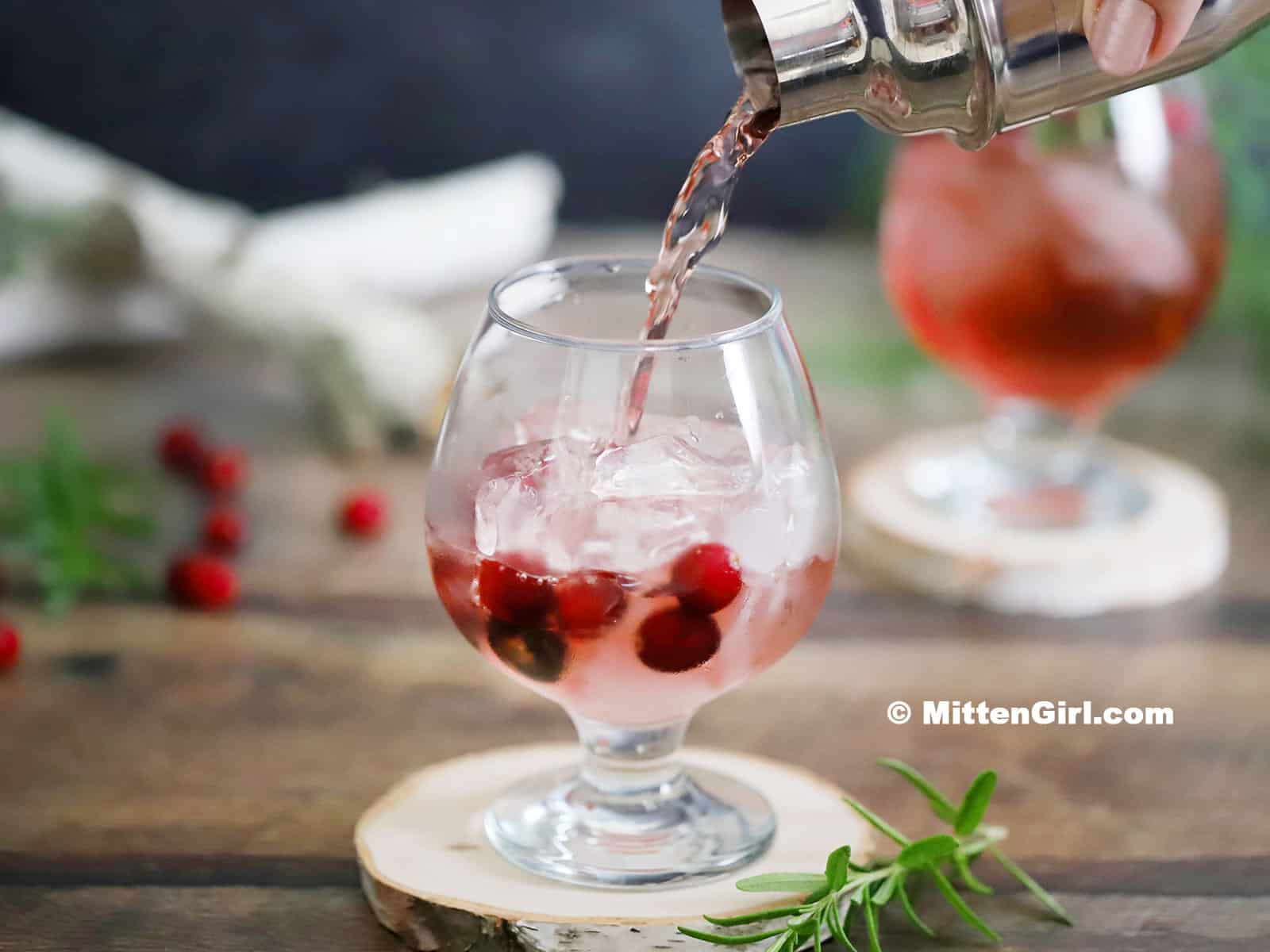 A cranberry gin cocktail being poured