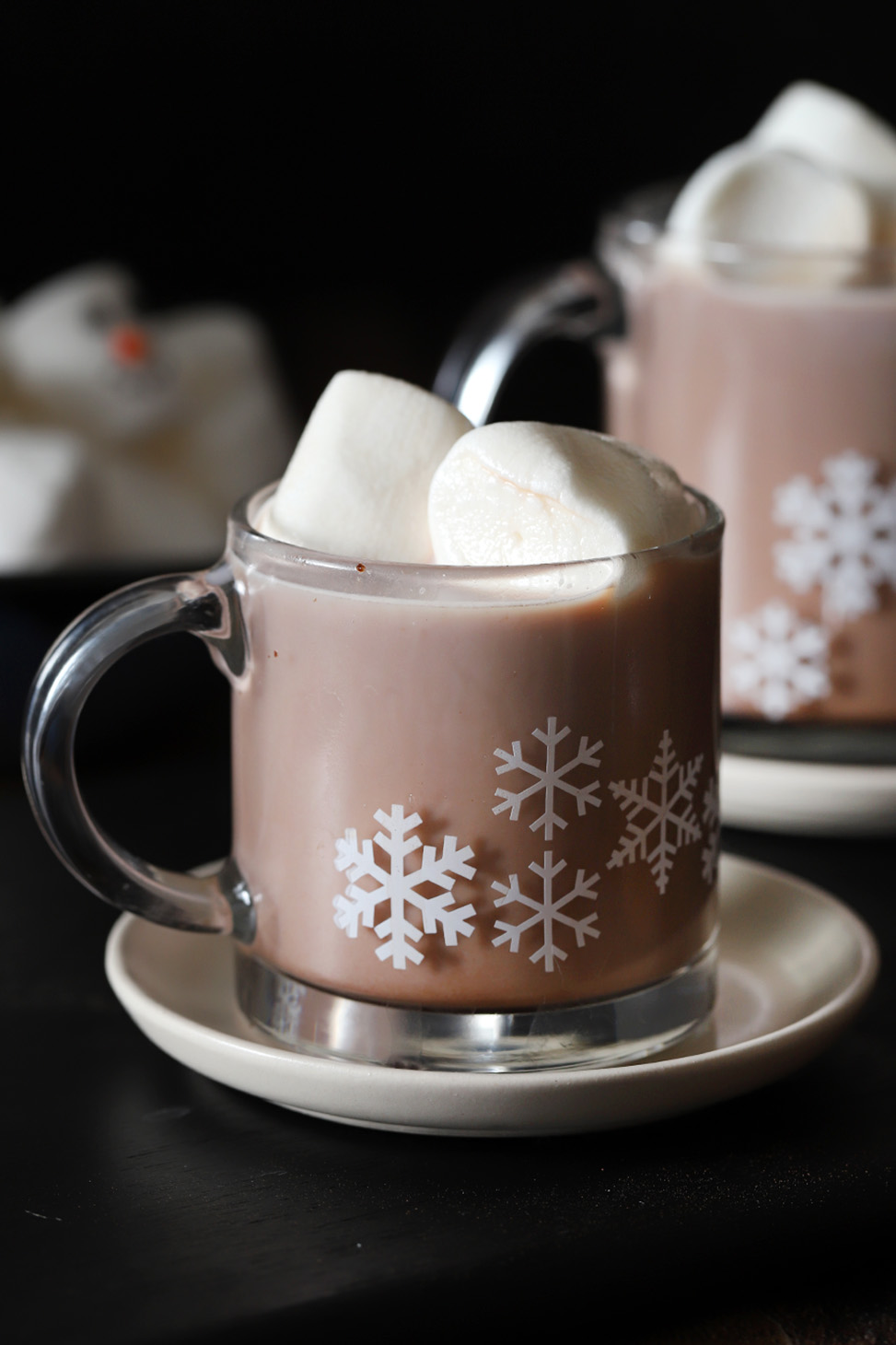 Mugs of hot chocolate topped with large marshmallows.