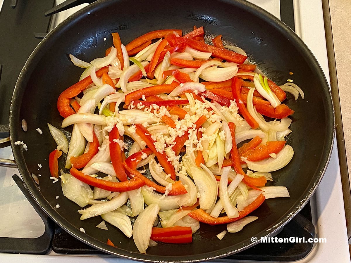 Peppers, onions, and garlic in a skillet