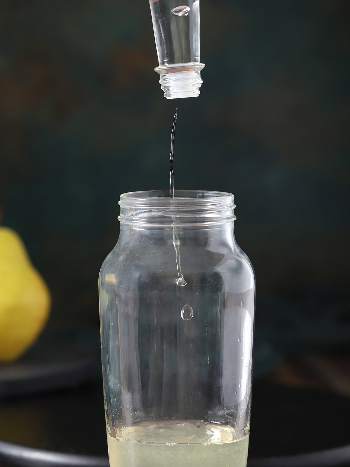 Cocktail foamer being dashed into a cocktail shaker.