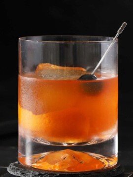 A rocks glass filled with old fashioned cocktail.