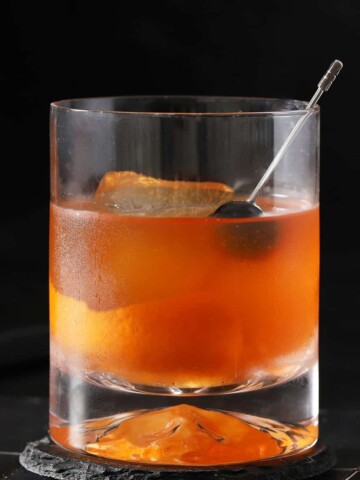 A rocks glass filled with old fashioned cocktail.