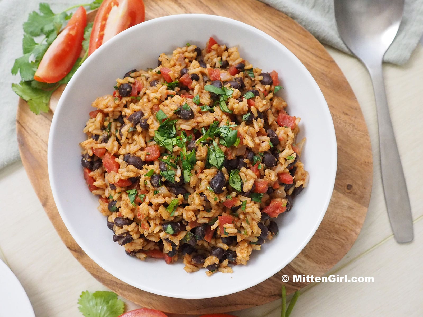 A large white dish filled with tomato rice and beans.