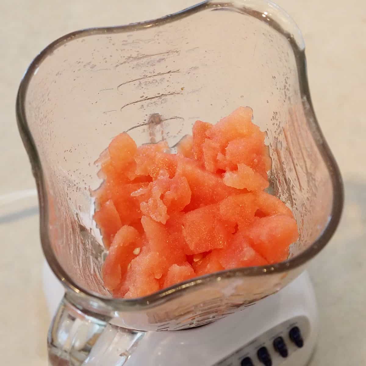 Chunks of watermelon in a countertop blender.