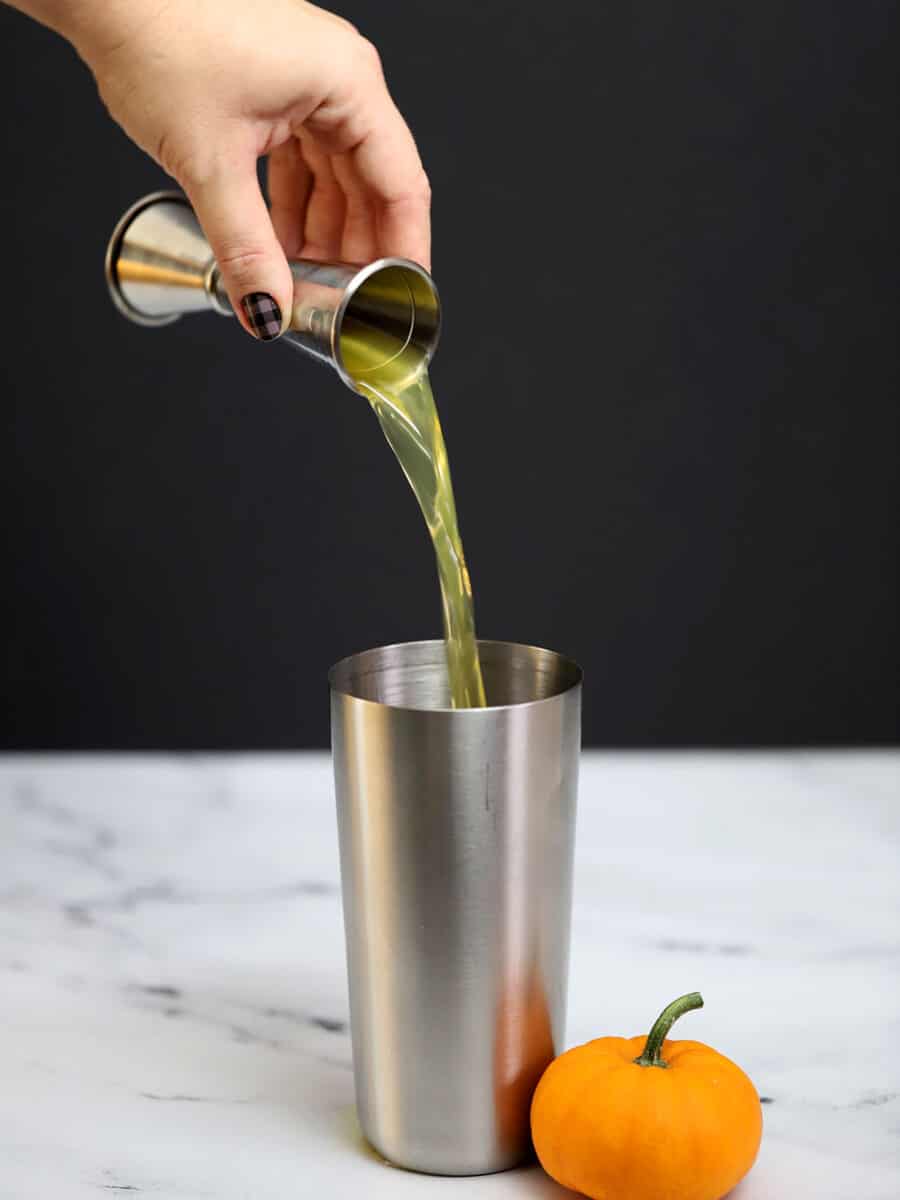 Pumpkin vodka being poured into a cocktail shaker