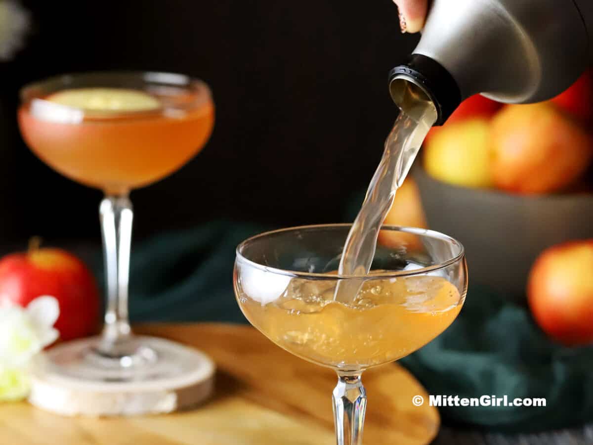 Apple Orchard Cocktail being poured into a coupe glass.