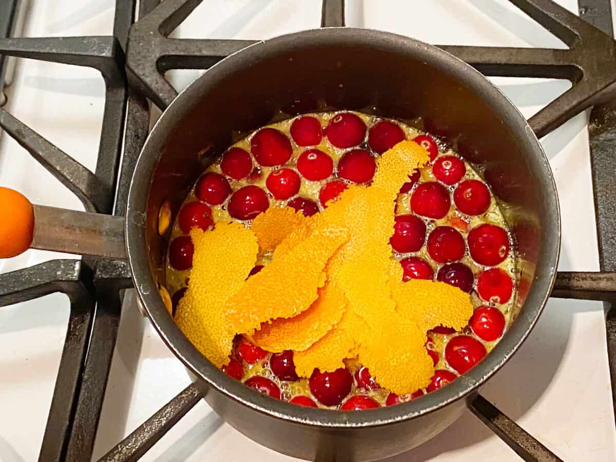 Cranberries, orange peel, sugar and water in a pot