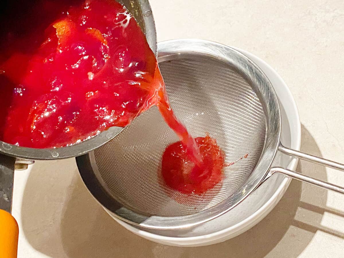 Straining cranberry orange syrup