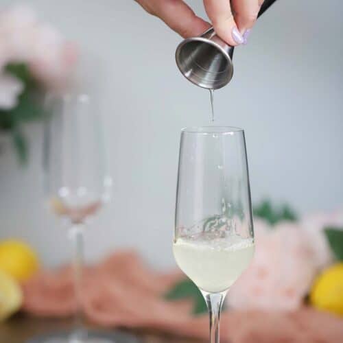 Syrup being poured into a champagne flute.