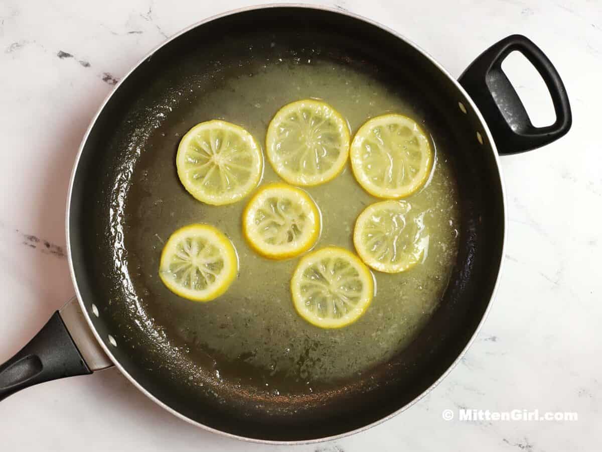 Cooked lemon slices with white wine, butter, and oil.