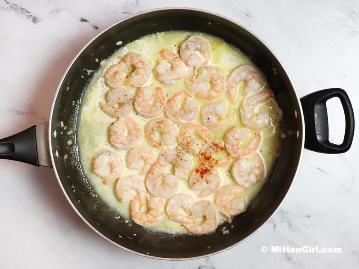 Cream added to the skillet of shrimp.
