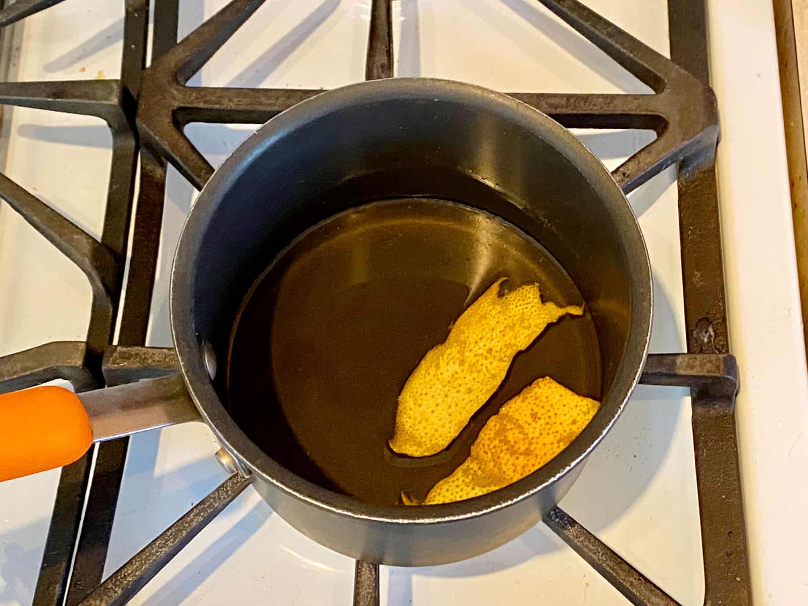 Grapefruit peel in a pot of hot simple syrup.