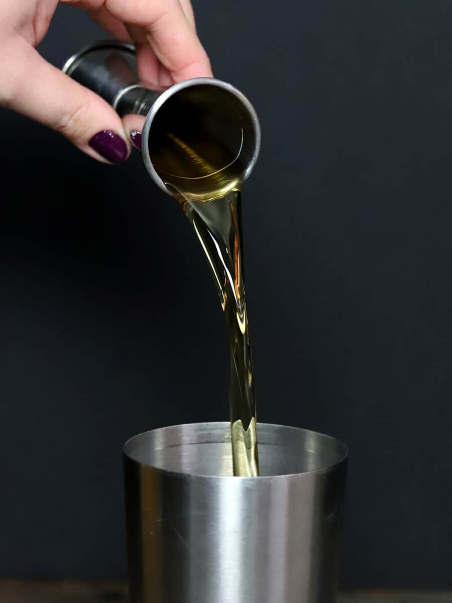 Peanut Butter Whiskey being poured into a cocktail shaker 