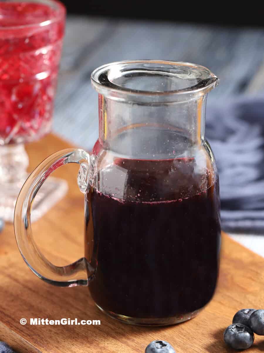 A pitcher of blueberry syrup.