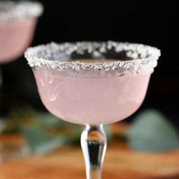 A glass filled with lavender lemon drop martini.