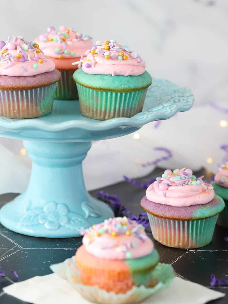 A cake stand full of colorful cupcakes.