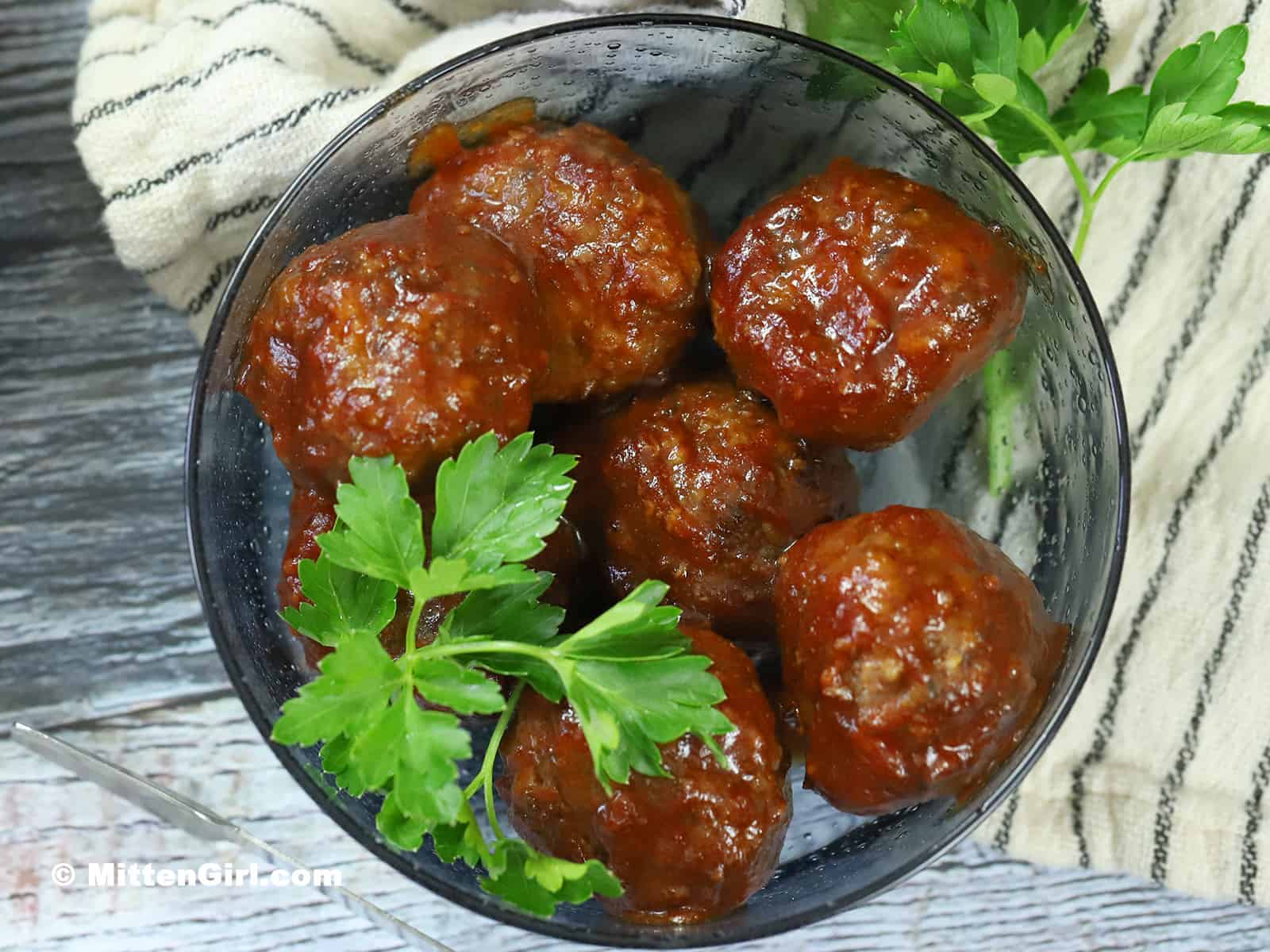 BBQ Meatballs in a bowl, garnished with parsley.