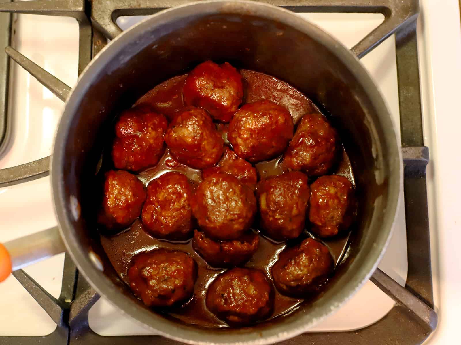 A pot full of cooked meatballs and sauce