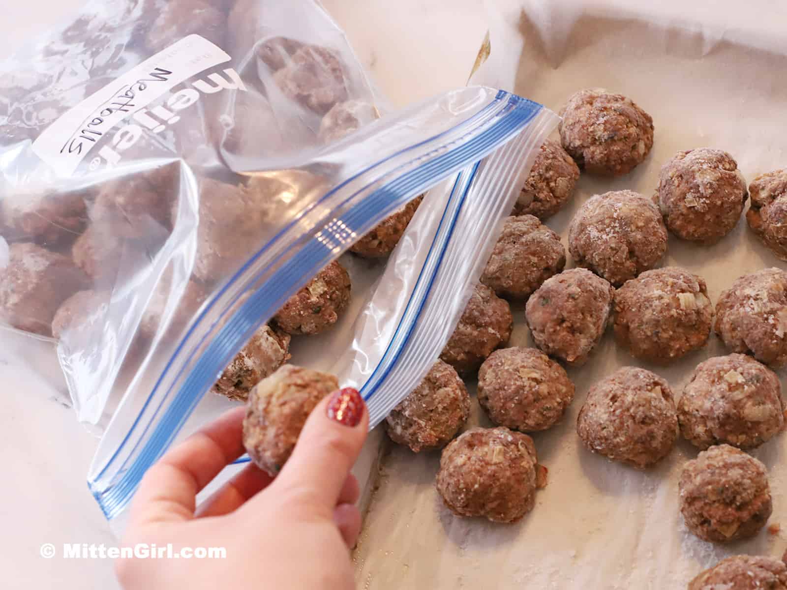 Placing frozen meatballs into a zip top bag.