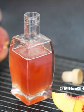 Homemade Peach Syrup in a bottle.
