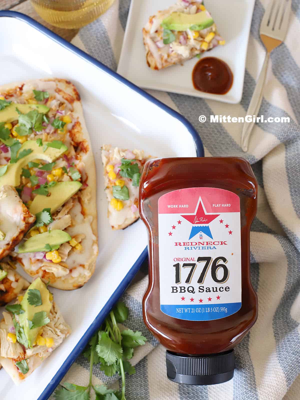 A bottle of 1776 BBQ Sauce with chicken pizza. 