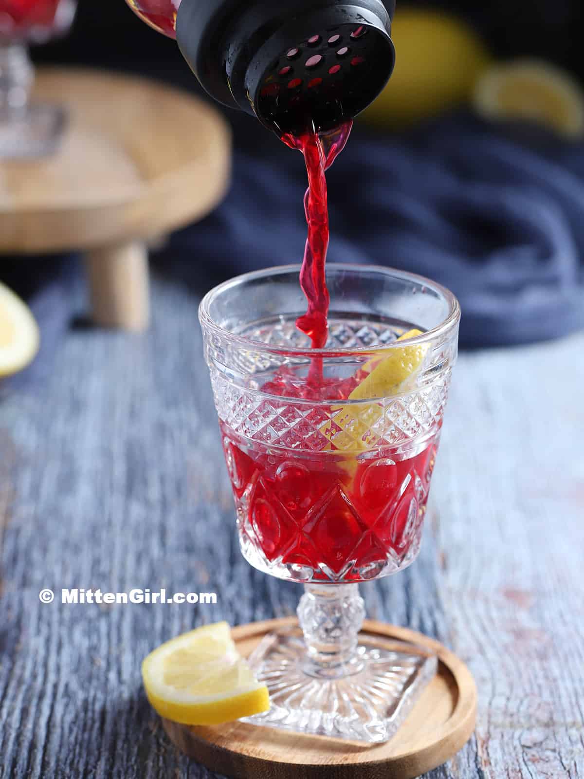 Pouring blueberry lemonade mixture into a glass.