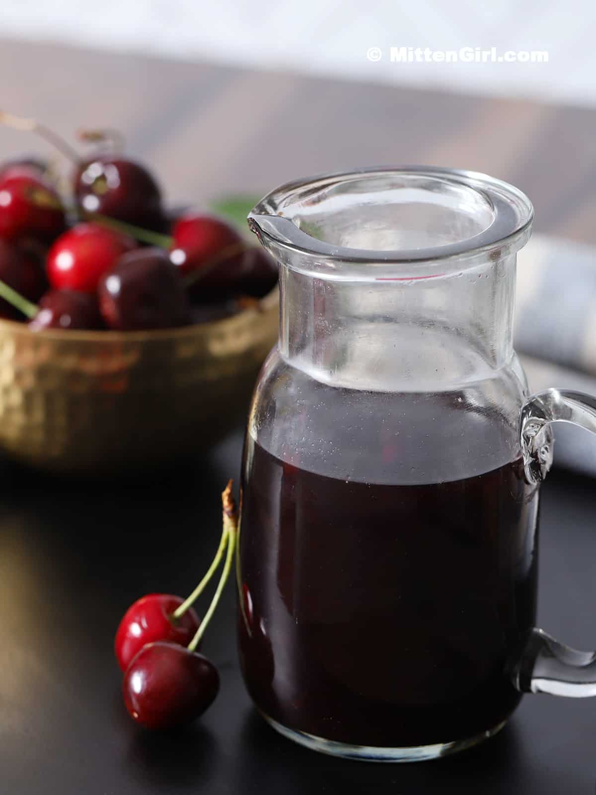 Finished cherry syrup in a small pitcher. 