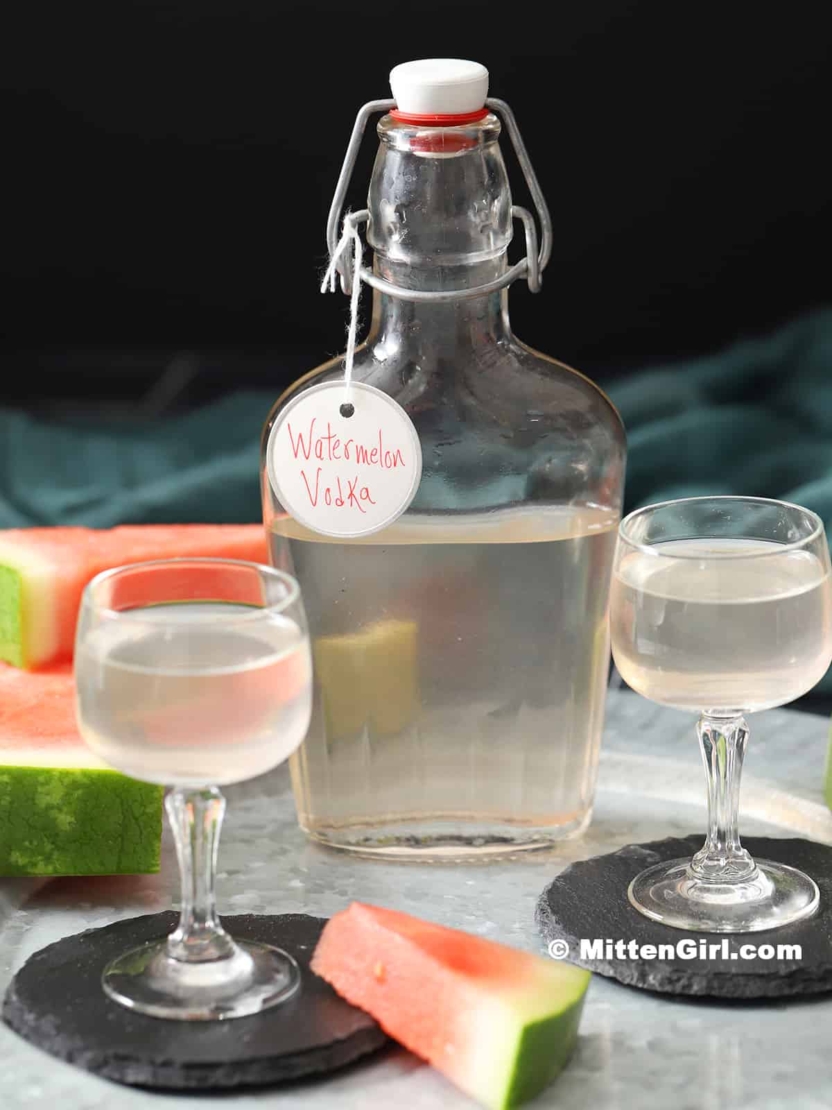 A bottle of watermelon vodka with two small glasses.