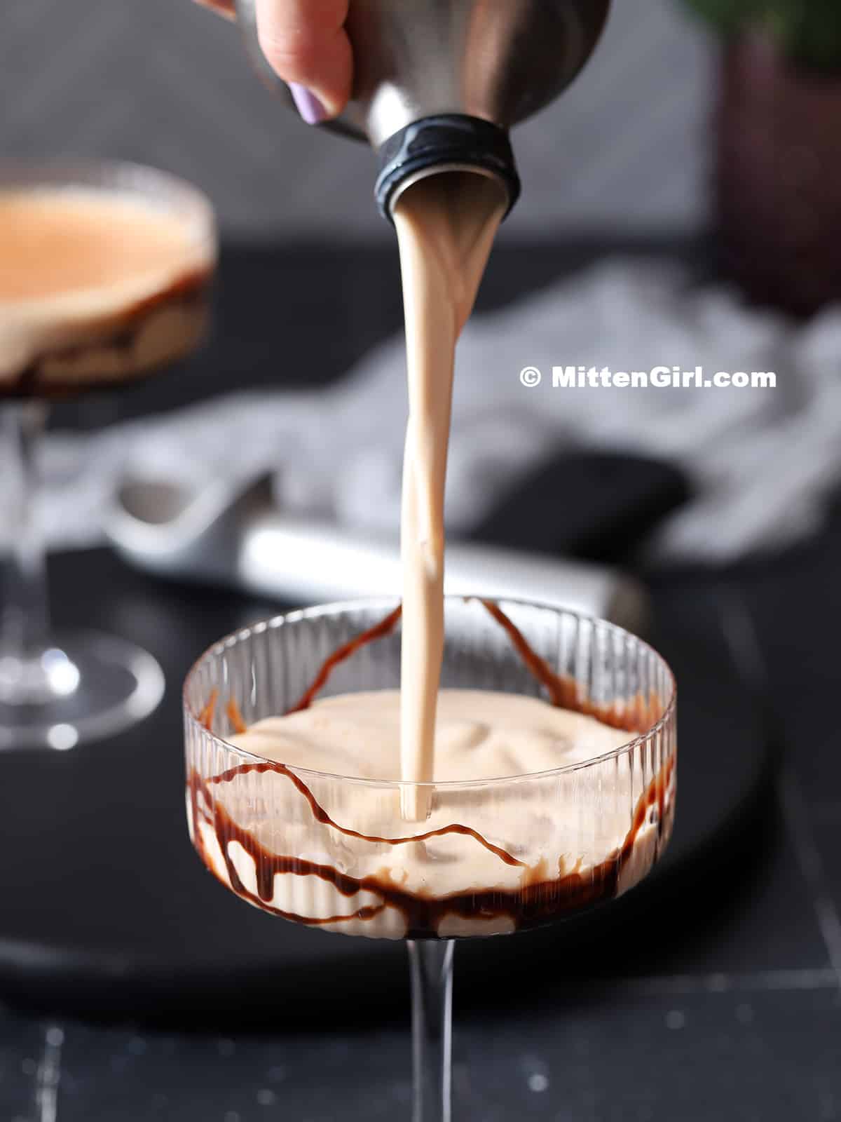 Chocolate caramel martini being poured from a cocktail shaker into a glass. 