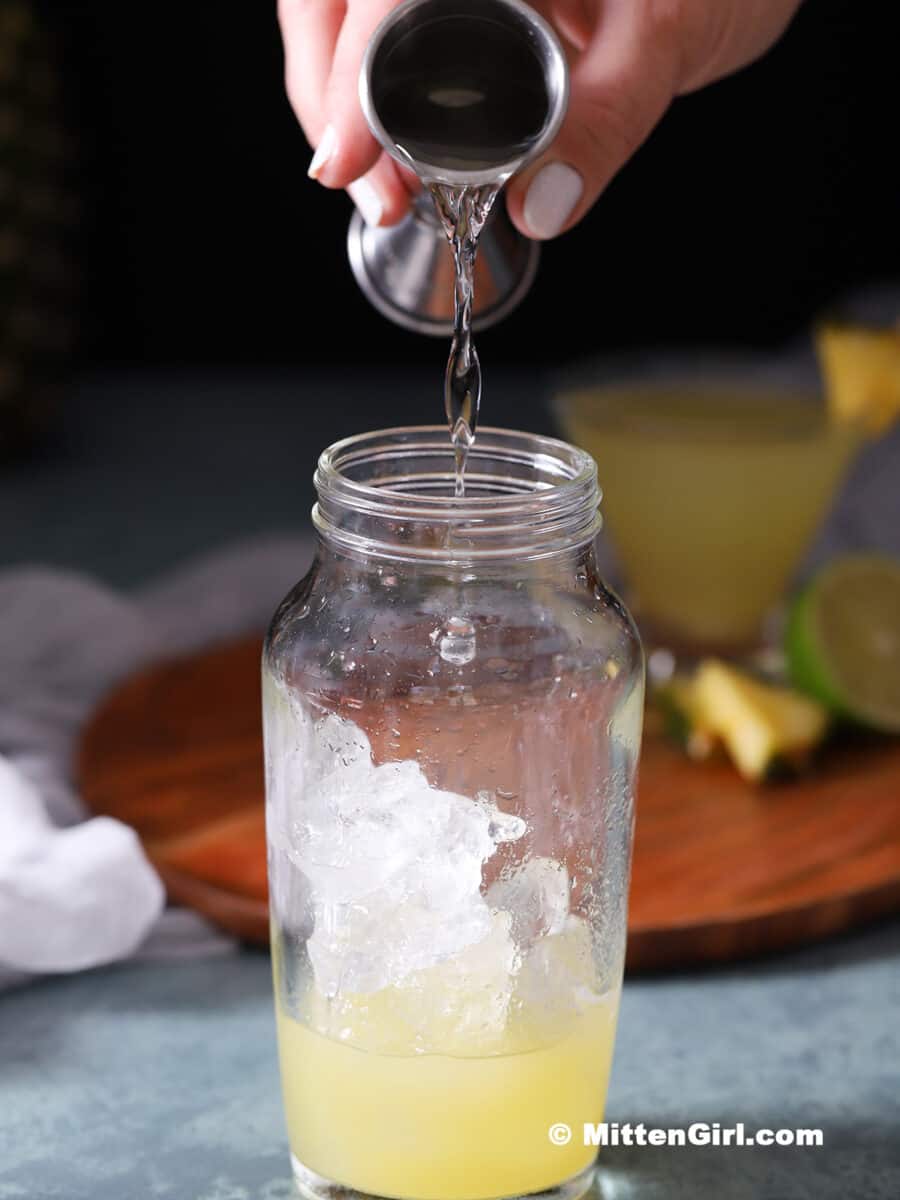 Vodka being poured into a cocktail shaker.