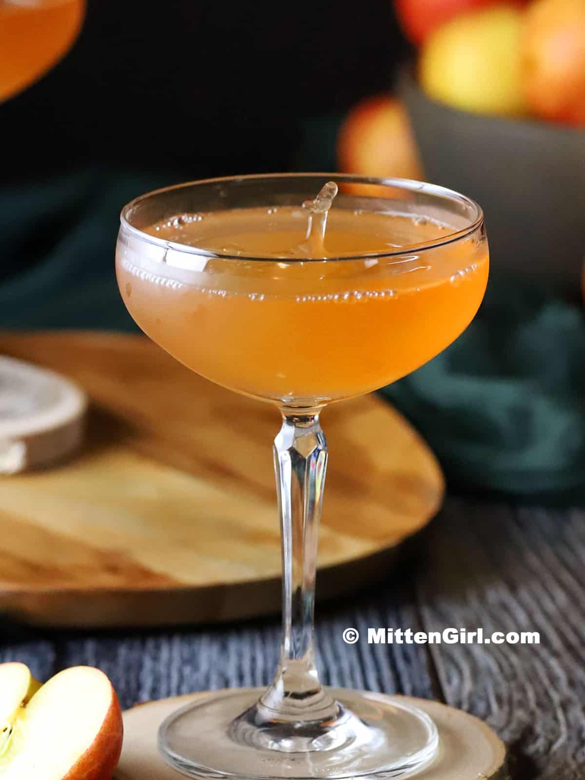 A coupe glass with a splash of cocktail jumping up in it.