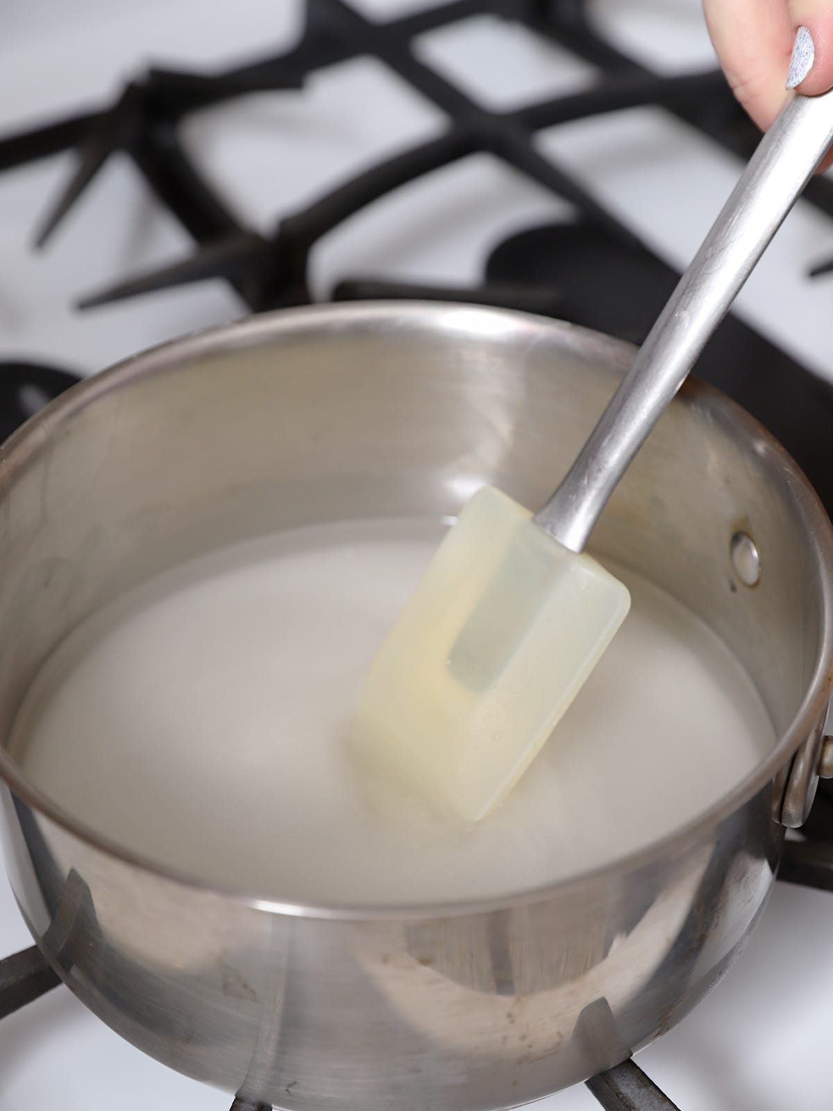 A spatula stirring sugar and water. 