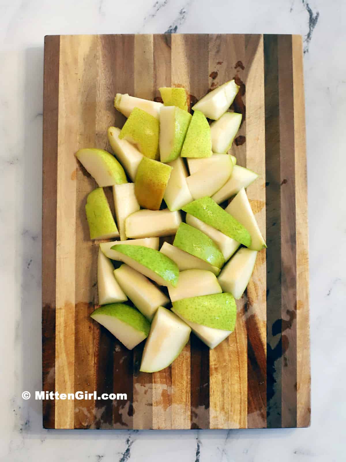 A cutting board full of sliced pears. 