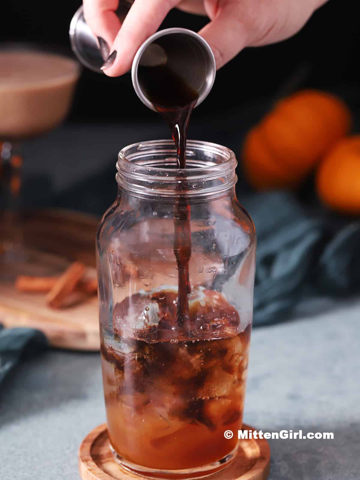 Cold brew coffee being poured into a cocktail shaker. 