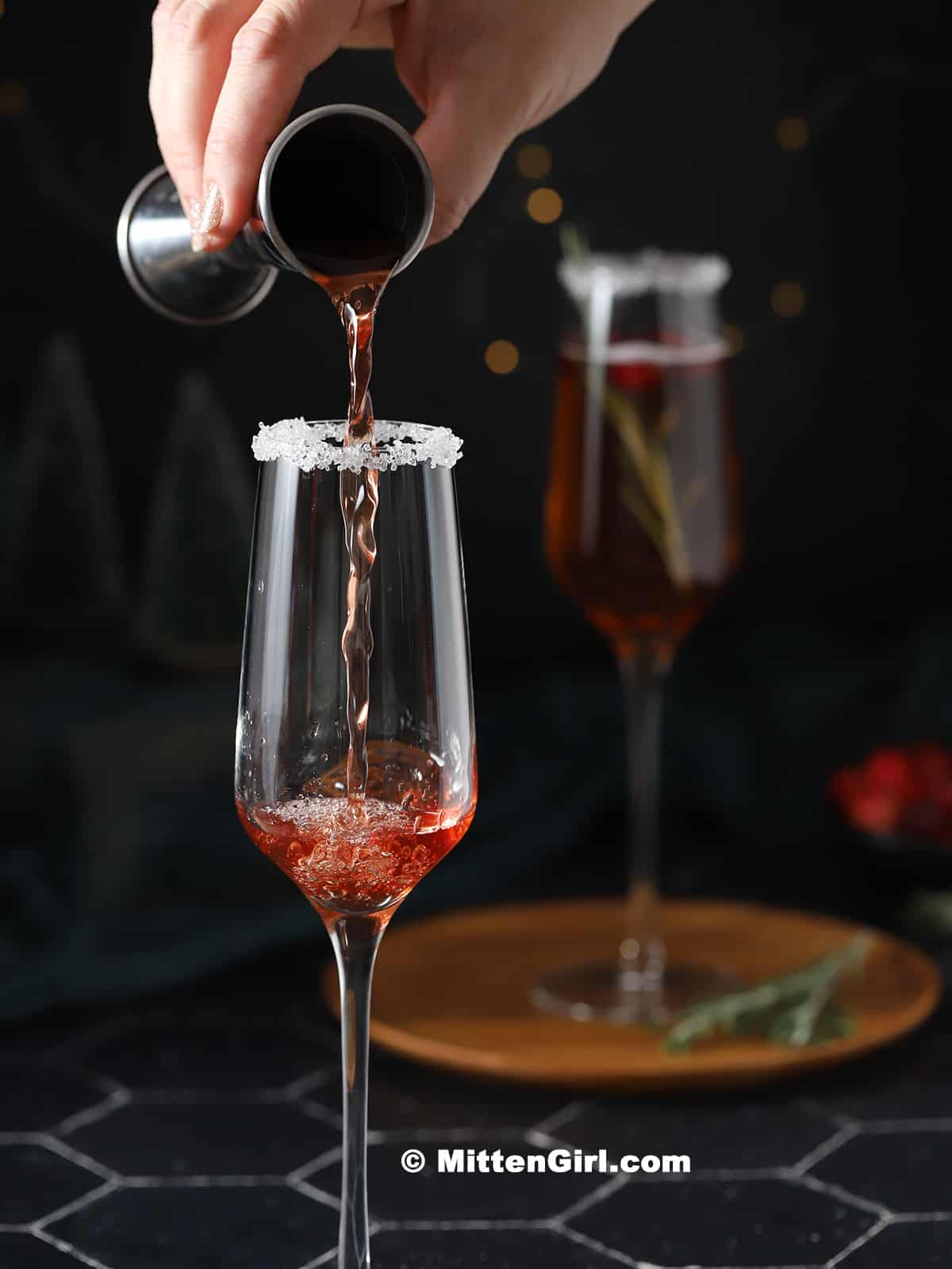 Cranberry juice bring poured in to a champagne flute. 