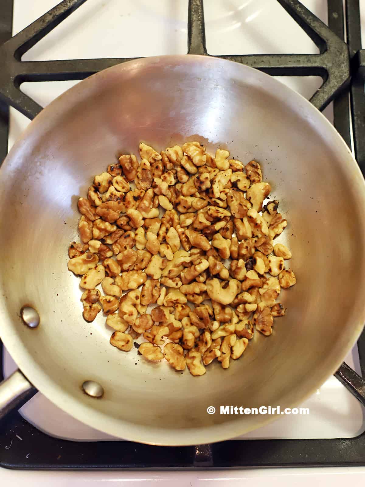 Walnuts toasting in a pan. 