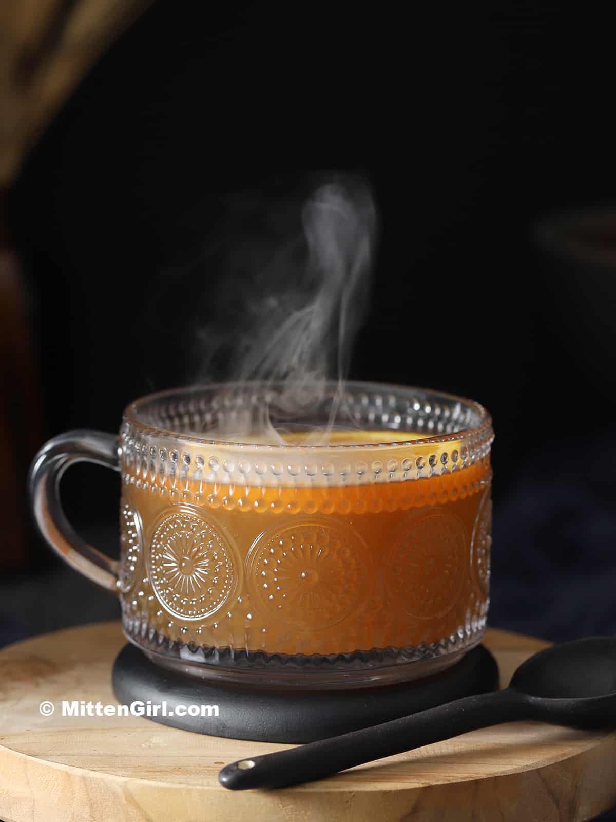 A steaming mug of bourbon hot toddy cocktail.