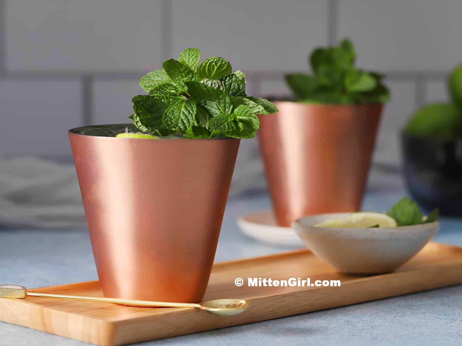 Copper cups filled with moscow mule mocktails and garnished with mint.